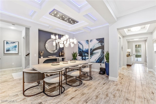 dining space with light hardwood / wood-style floors, crown molding, and coffered ceiling