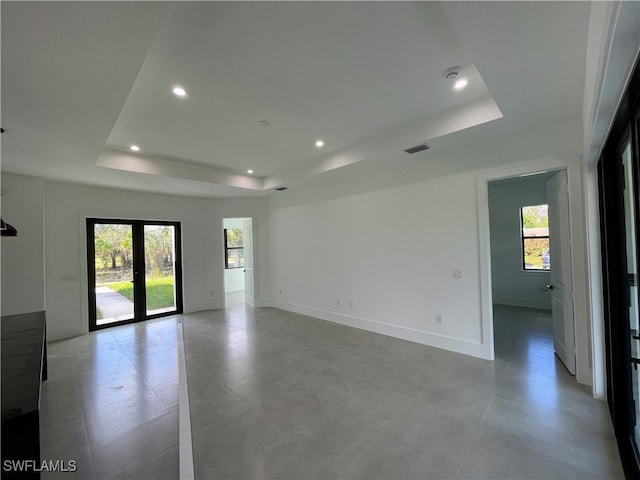 unfurnished room with french doors and a tray ceiling