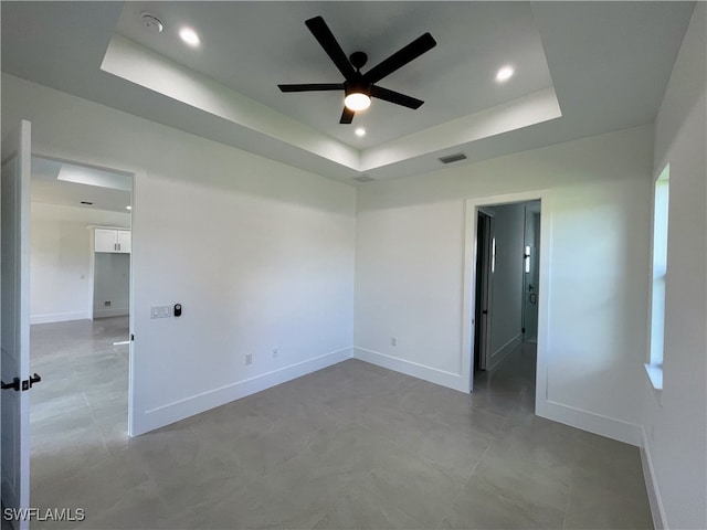 spare room featuring ceiling fan and a tray ceiling