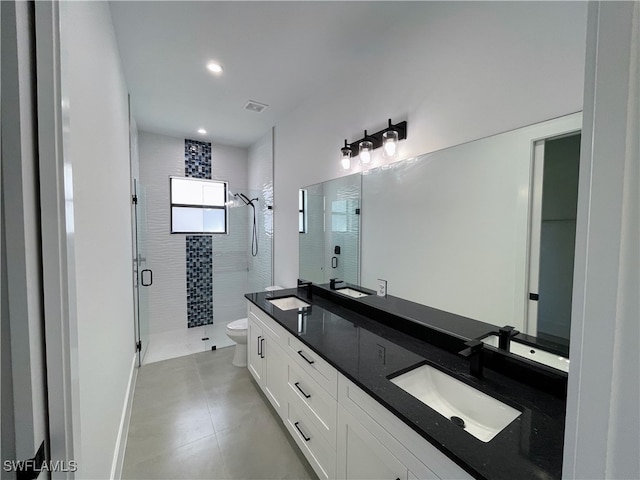 bathroom featuring a shower with door, vanity, and toilet