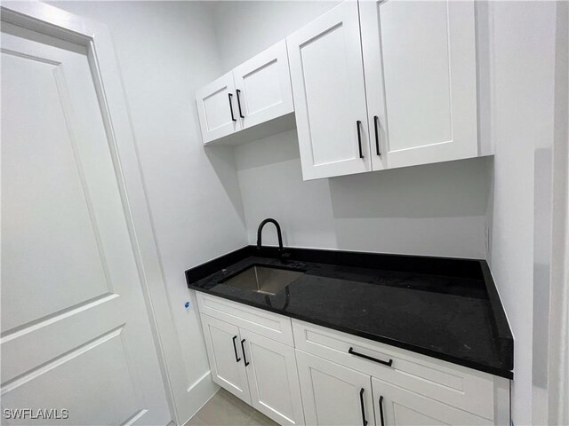 442 4th St SE, Naples, FL 34117 - kitchen featuring a sink, white cabinetry, and dark stone counters