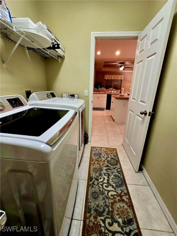 washroom featuring washer and dryer, ceiling fan, and light tile patterned floors