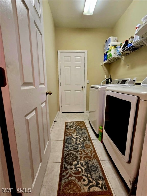 laundry area featuring washer and dryer and light tile patterned flooring