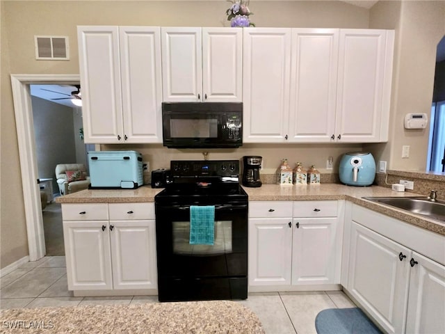 kitchen with ceiling fan, sink, black appliances, light tile patterned floors, and white cabinets