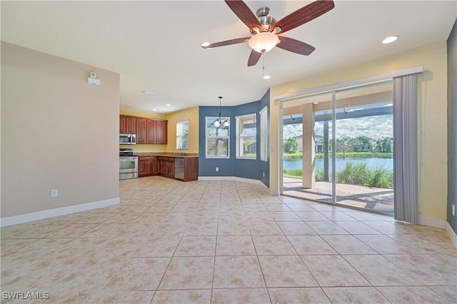 unfurnished living room featuring ceiling fan with notable chandelier, a water view, and light tile patterned floors