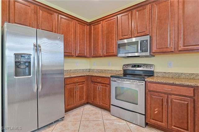 kitchen featuring light stone counters, light tile patterned flooring, and appliances with stainless steel finishes