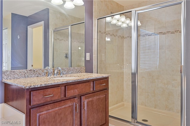 bathroom with vanity and a shower with door