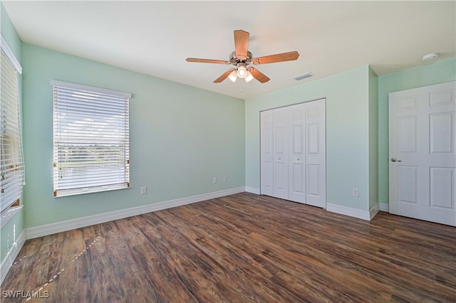 unfurnished bedroom with ceiling fan, a closet, and dark hardwood / wood-style floors