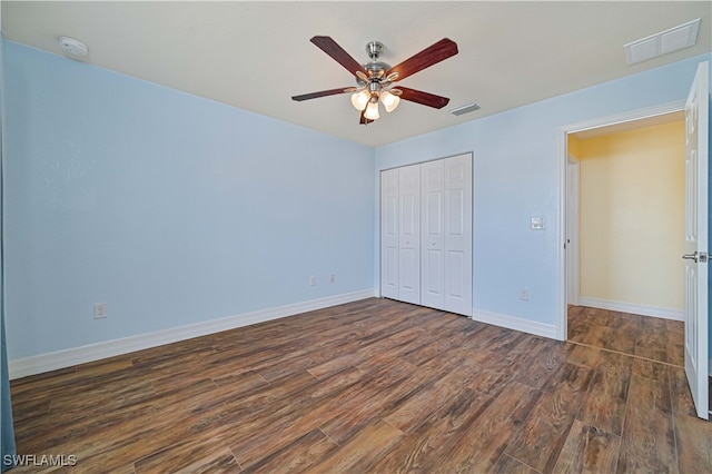 unfurnished bedroom with ceiling fan, a closet, and dark hardwood / wood-style floors