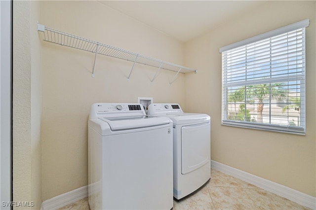 washroom featuring light tile patterned floors and washing machine and clothes dryer