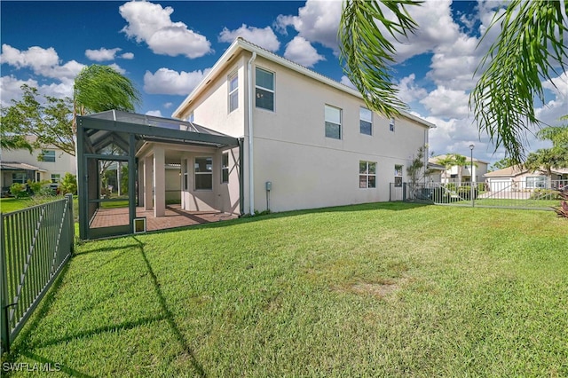 back of property with a yard, a patio area, and a lanai