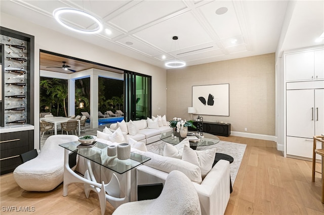 living room featuring ceiling fan, light hardwood / wood-style floors, and coffered ceiling