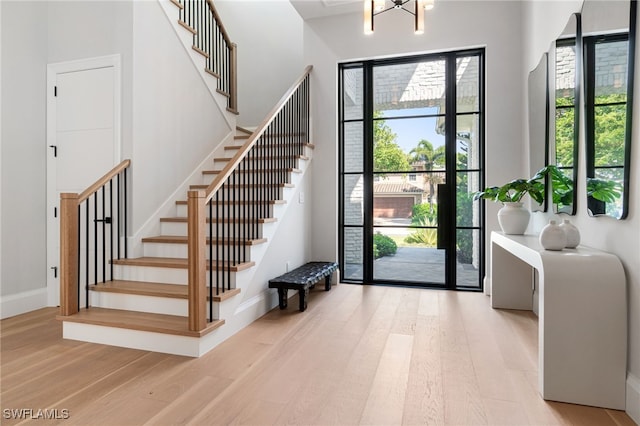 entryway with light hardwood / wood-style floors and a chandelier