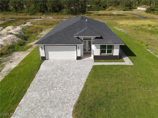 view of front of property with a garage, french doors, and a front yard