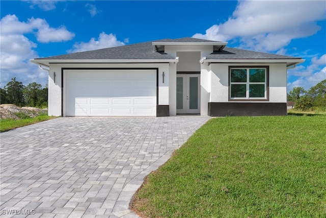 view of front of home with a front yard, french doors, and a garage