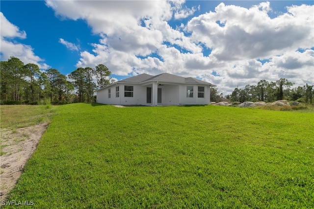 rear view of property featuring a lawn