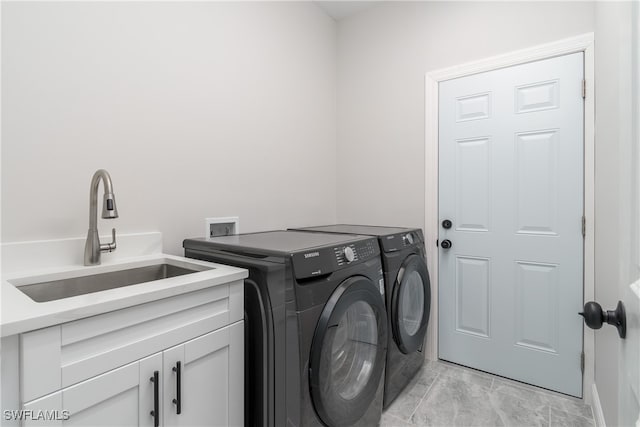 laundry area with cabinets, sink, and separate washer and dryer