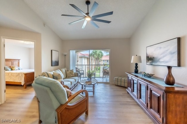 living room featuring light hardwood / wood-style flooring, ceiling fan, and lofted ceiling