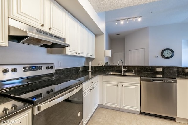 kitchen with dark stone countertops, sink, white cabinetry, and stainless steel appliances