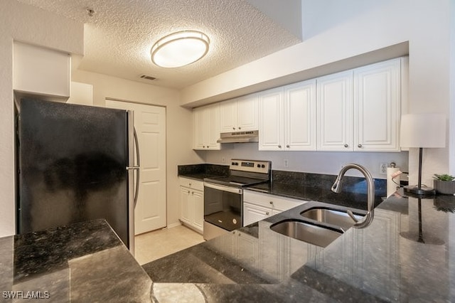 kitchen featuring stainless steel range with electric stovetop, sink, black fridge, and a textured ceiling