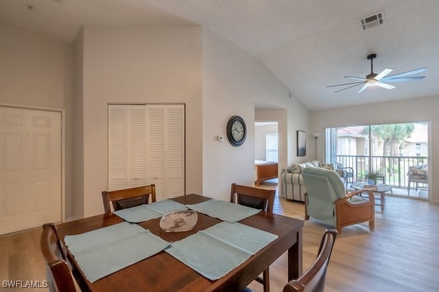 dining area featuring light hardwood / wood-style floors, high vaulted ceiling, and ceiling fan