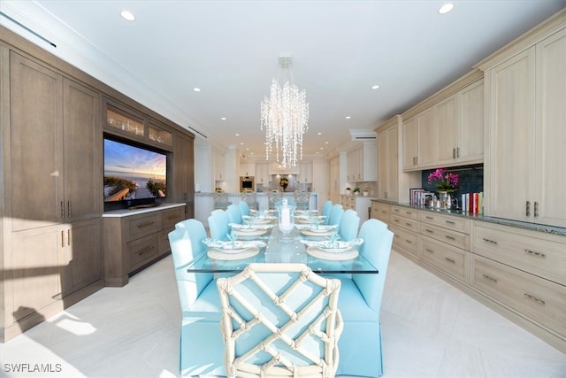 kitchen featuring light stone countertops, a kitchen breakfast bar, a chandelier, decorative light fixtures, and ornamental molding