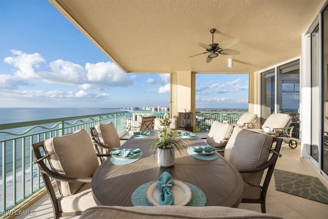 balcony with a water view and ceiling fan