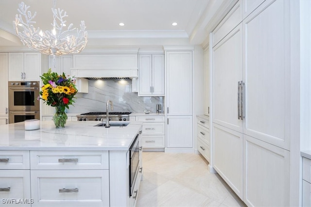 kitchen featuring backsplash, custom exhaust hood, stainless steel appliances, white cabinetry, and hanging light fixtures