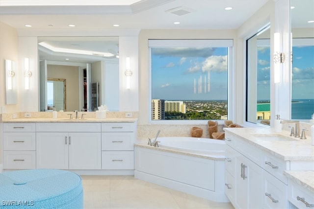 bathroom featuring tile patterned floors, vanity, a bathtub, and a water view