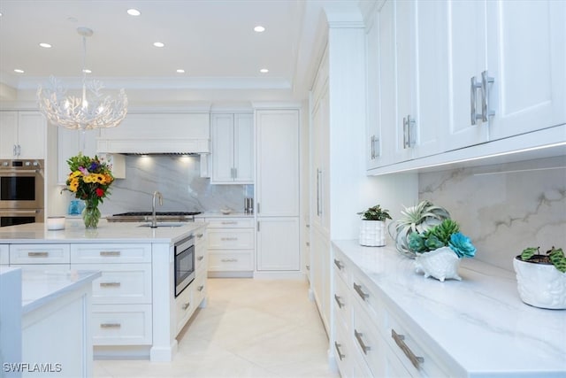 kitchen with stainless steel appliances, decorative backsplash, white cabinets, and hanging light fixtures