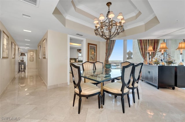 dining room with a raised ceiling, an inviting chandelier, and crown molding