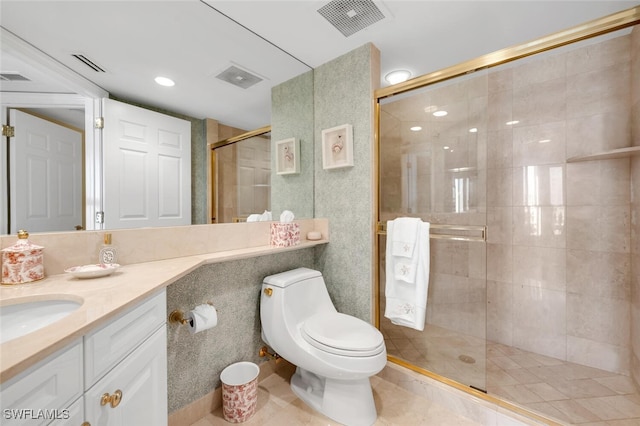 bathroom with vanity, tile patterned floors, toilet, walk in shower, and tile walls