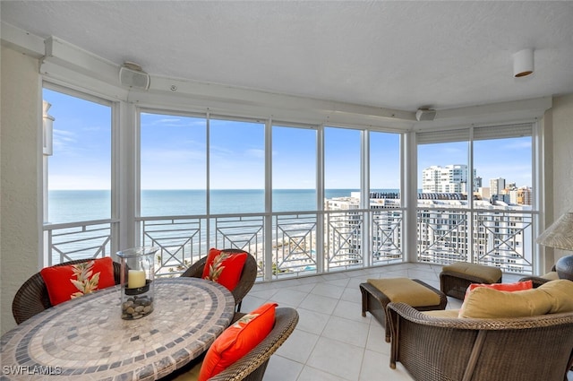 sunroom featuring a water view