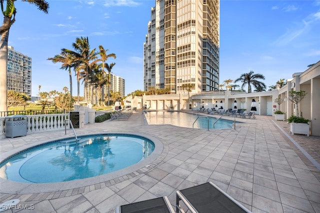 view of swimming pool featuring an in ground hot tub and a patio area