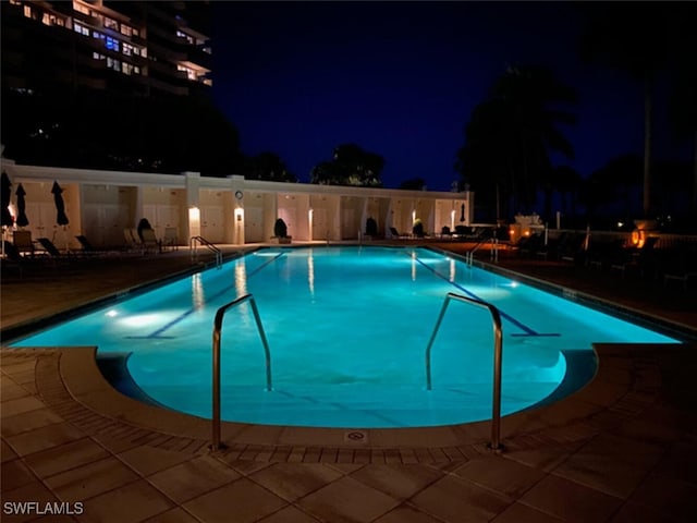 pool at twilight featuring a patio area