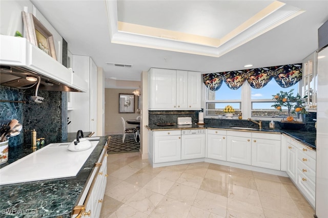 kitchen with white cabinets, a tray ceiling, and sink