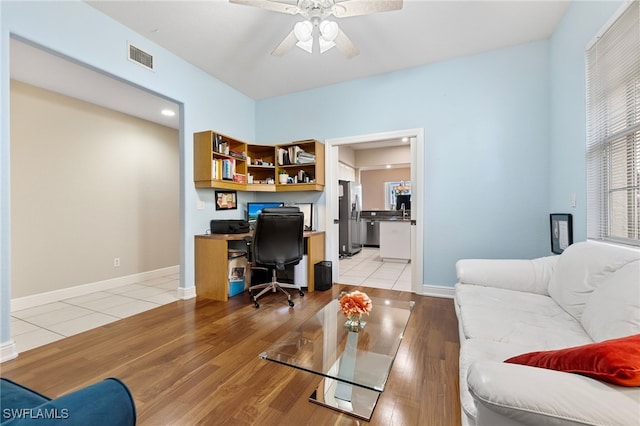 office with visible vents, baseboards, light wood-type flooring, and a ceiling fan