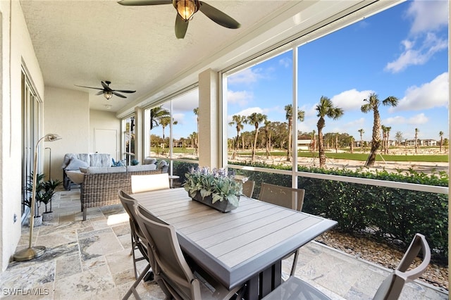 sunroom / solarium featuring ceiling fan