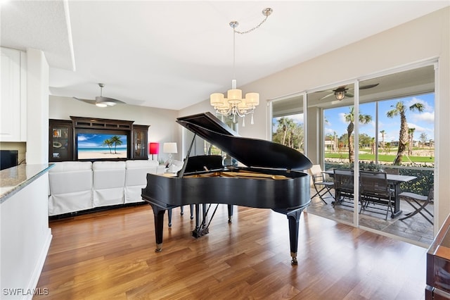 misc room featuring hardwood / wood-style floors and ceiling fan with notable chandelier