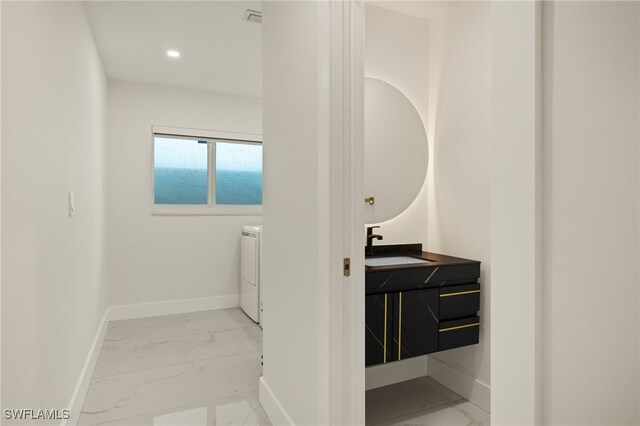 bathroom featuring vanity and washer / clothes dryer