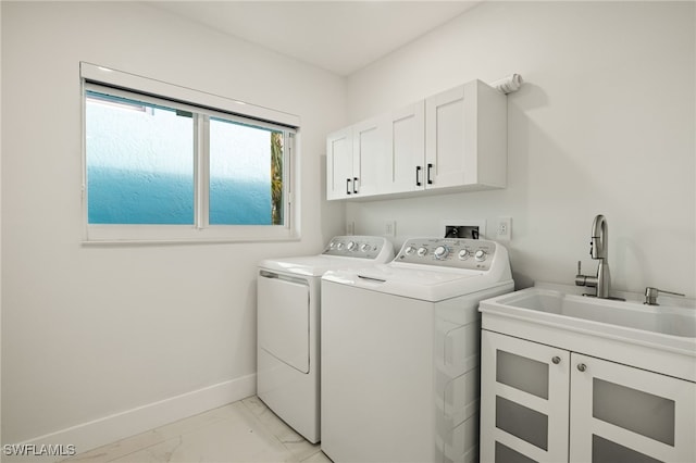 laundry area with baseboards, washer and dryer, cabinet space, marble finish floor, and a sink