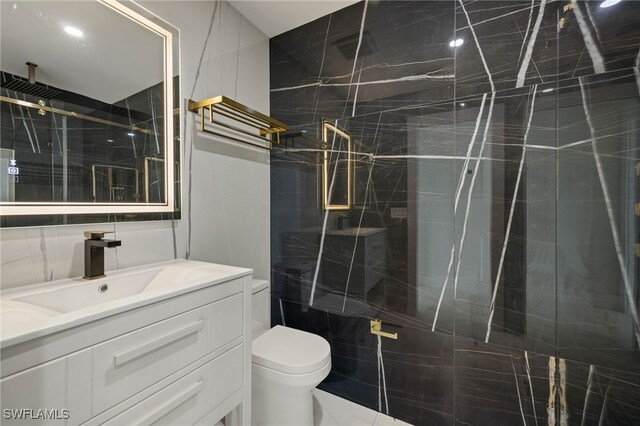 bathroom featuring tile walls, an enclosed shower, vanity, and toilet