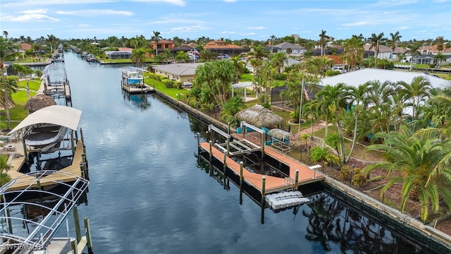 view of dock featuring a water view, a residential view, and boat lift