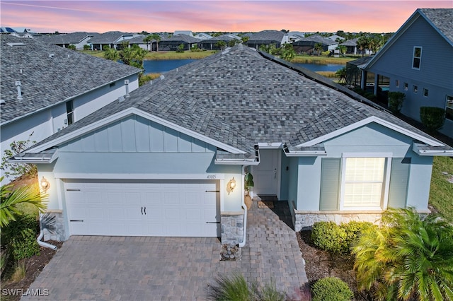 view of front of home with a garage and a water view