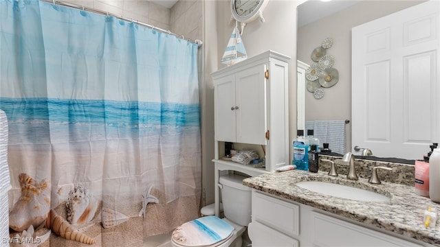 bathroom with toilet, vanity, and curtained shower