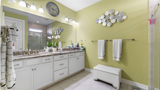 bathroom with tile patterned floors, vanity, and a shower with door