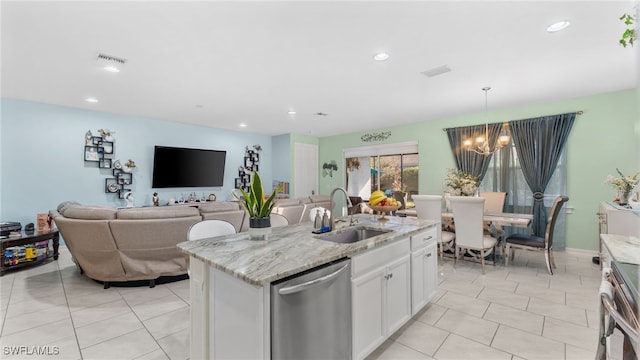 kitchen featuring stainless steel appliances, sink, an island with sink, light stone countertops, and white cabinetry