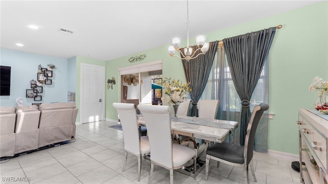 tiled dining room featuring an inviting chandelier