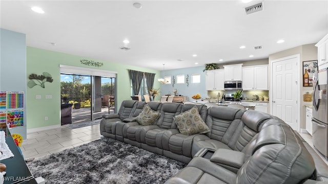 tiled living room with a notable chandelier and sink