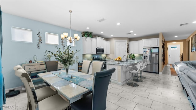 dining area featuring sink and an inviting chandelier